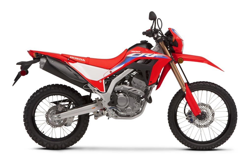 2026 Honda CRF300L dual-sport motorcycle in red with white number panels, right-side studio profile on a white background
