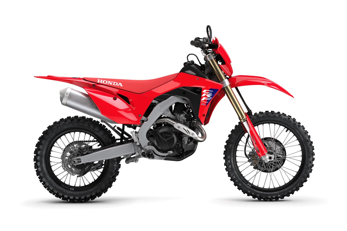 2027 Honda CRF450X enduro motorcycle in red and black, right-side studio profile showing gold-anodized forks and skid-plated engine