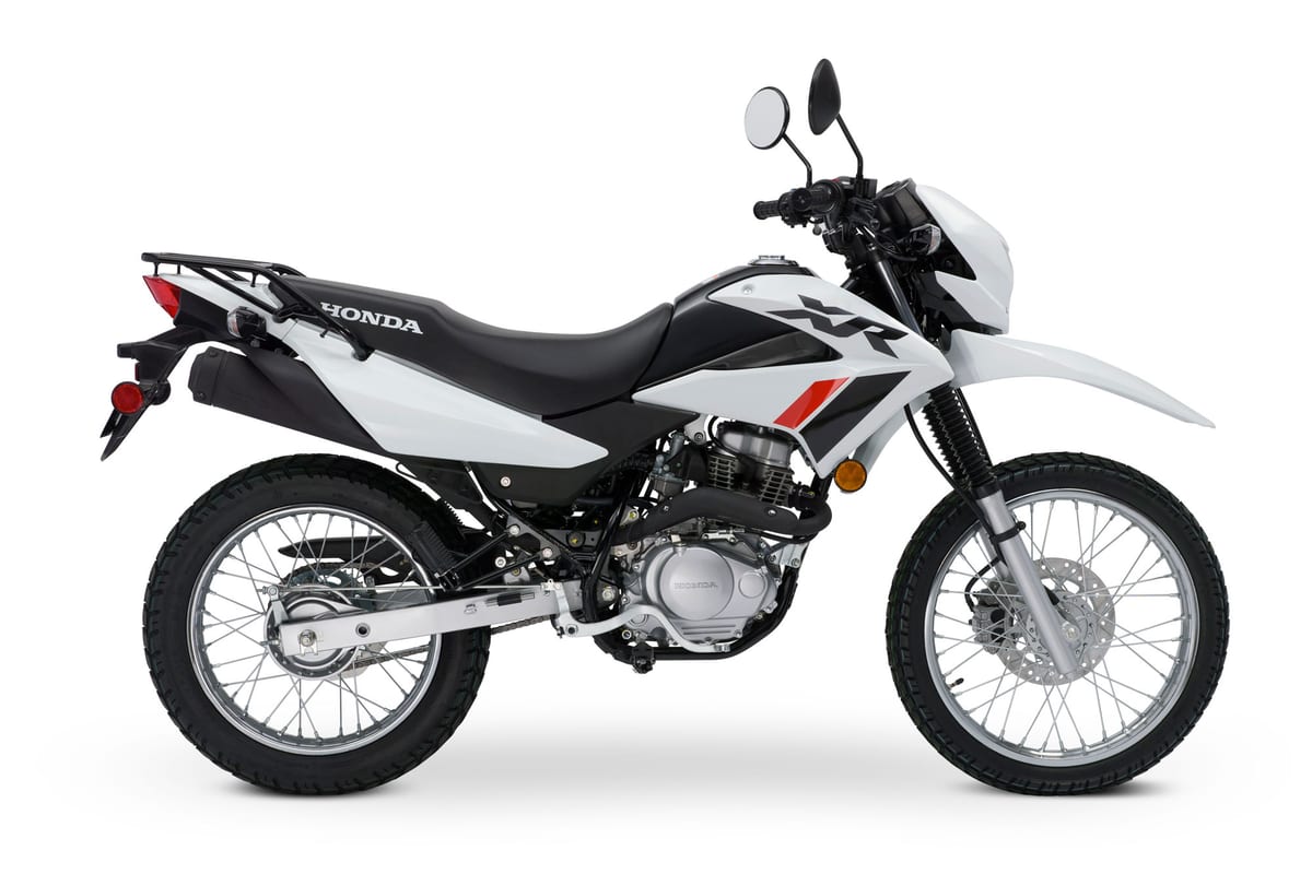 Honda XR150L white and black, opposite right-side studio angle highlighting the exhaust, engine cases and front disc brake