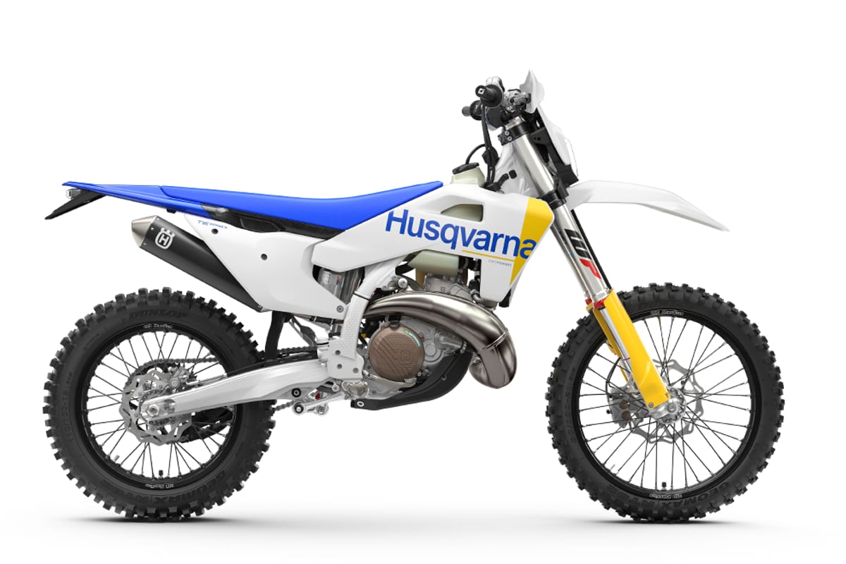 2027 Husqvarna TE 250 two-stroke enduro in white and blue, right-side studio profile showing yellow WP forks and expansion chamber exhaust