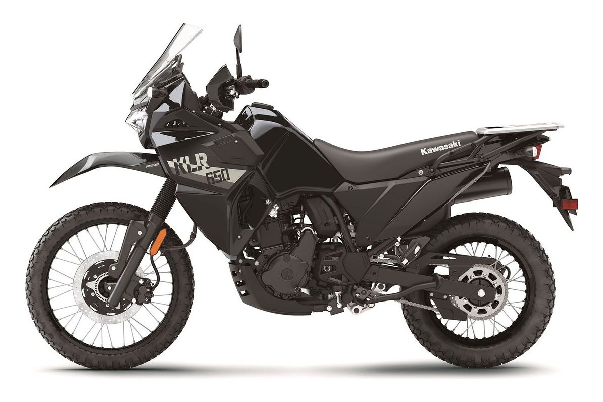 2026 Kawasaki KLR650 dual-sport in orange and black, right-side studio profile showing the tall windscreen, spoked wheels and rear luggage rack