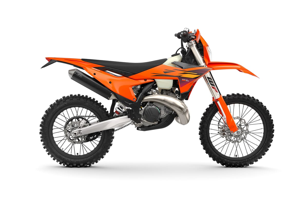 2027 KTM 250 XC-W enduro in orange, left-side studio profile showing the WP forks, expansion chamber and cross-spoked wheels