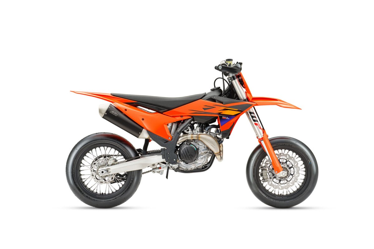 2026 KTM 450 SMR supermoto in orange, right-side studio profile showing WP inverted forks, slip-on exhaust and slick supermoto wheels