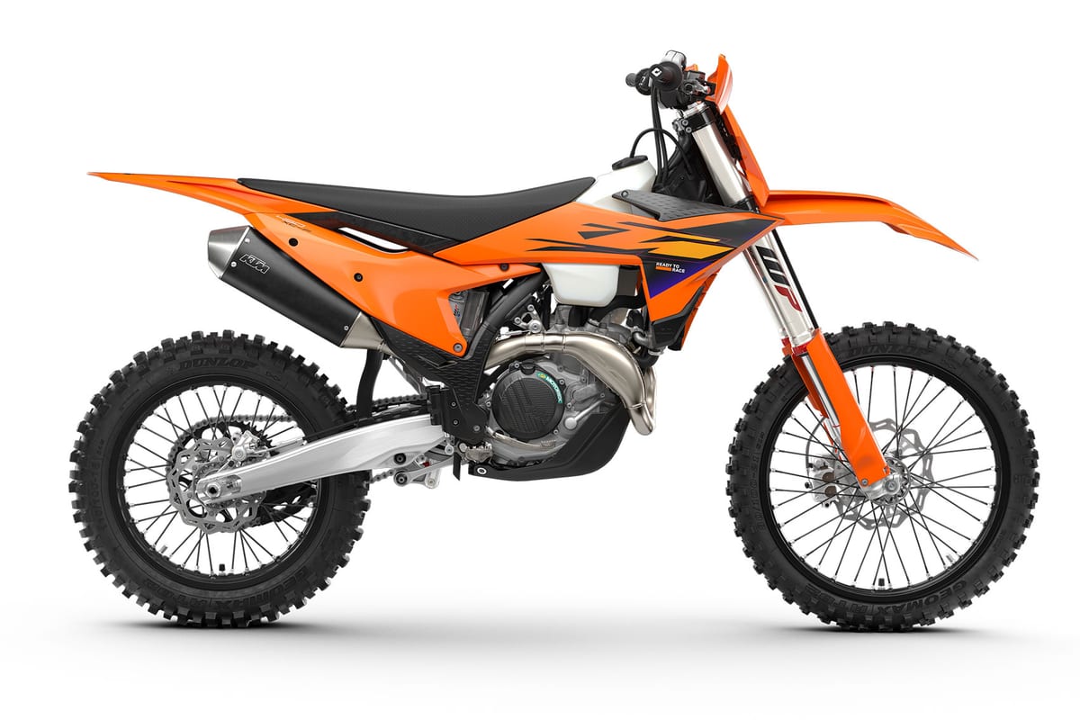 2027 KTM 450 XC-F cross-country motorcycle in orange with black seat, left-side studio profile showing inverted WP fork and Dunlop tires