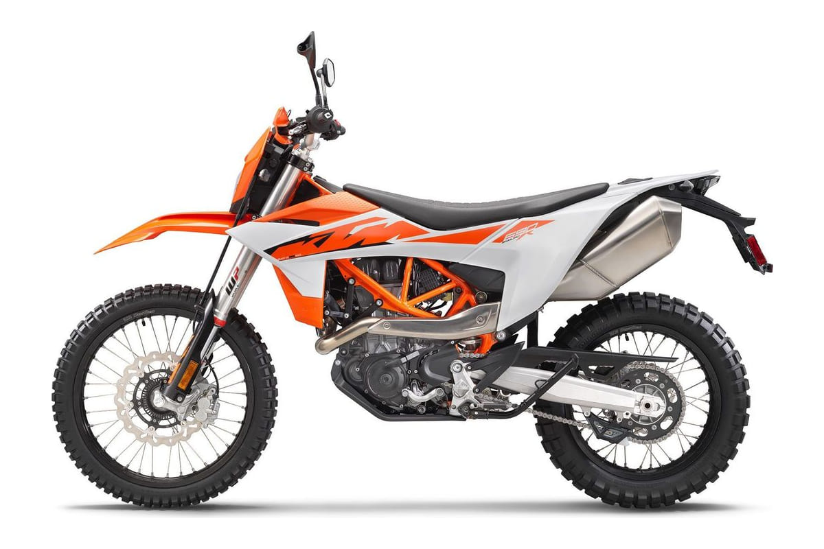 2026 KTM 690 Enduro R in white and orange, right-side studio profile showing the tall windscreen, single-cylinder engine and knobby dual-sport tires