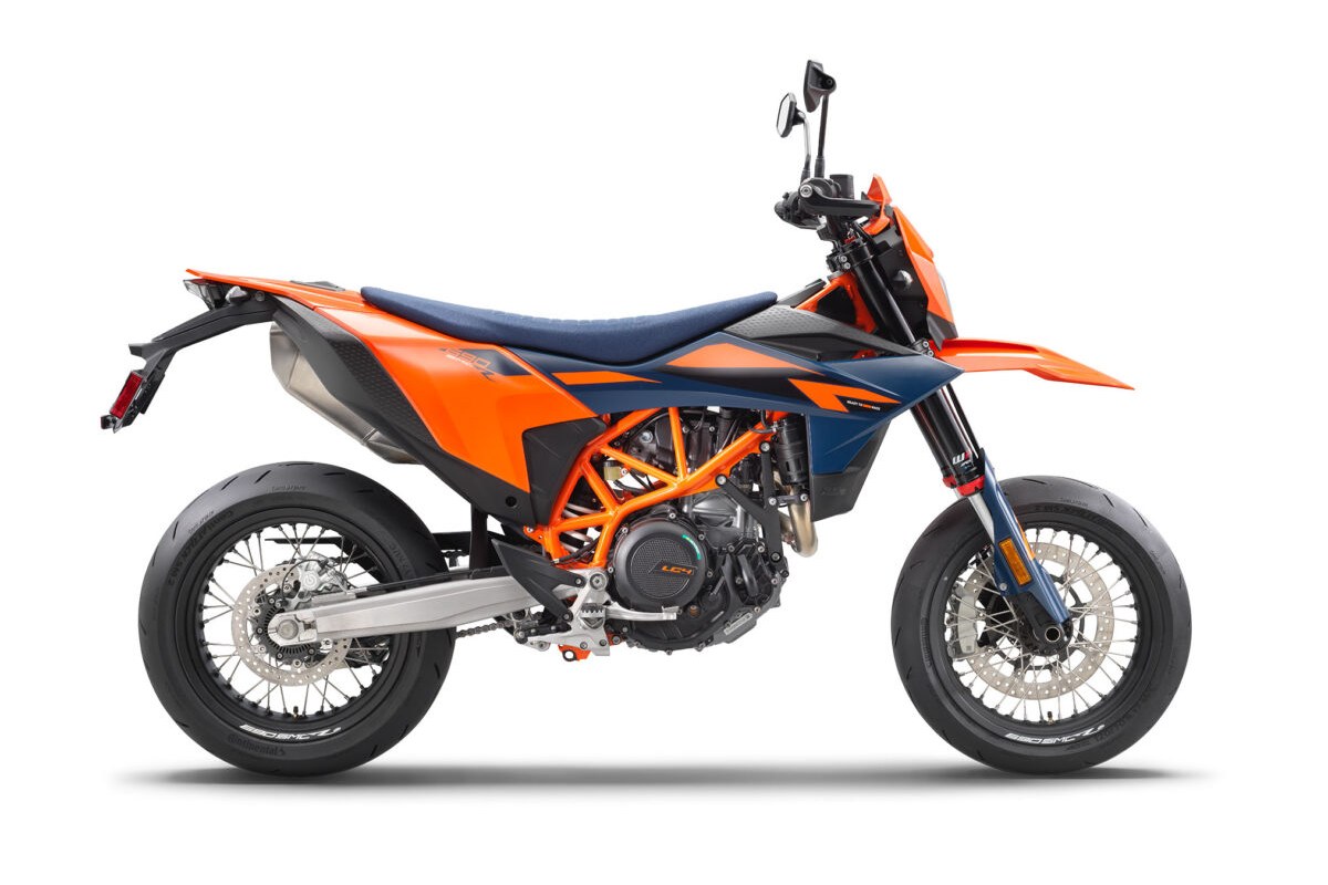 2026 KTM 690 SMC R supermoto in orange and blue with an orange trellis frame, right-side studio profile on street slicks over a white background