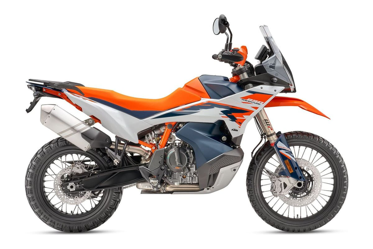 2026 KTM 890 Adventure R in orange, white and blue, right-side studio profile showing spoked wheels, long-travel WP forks and side-mounted exhaust