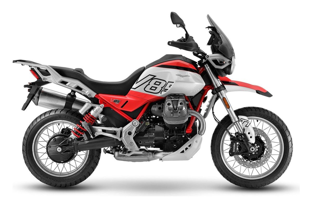 2027 Moto Guzzi V85 TT in white and red livery, right-side studio profile showing the transverse V-twin engine, spoked wheels and aluminum panniers