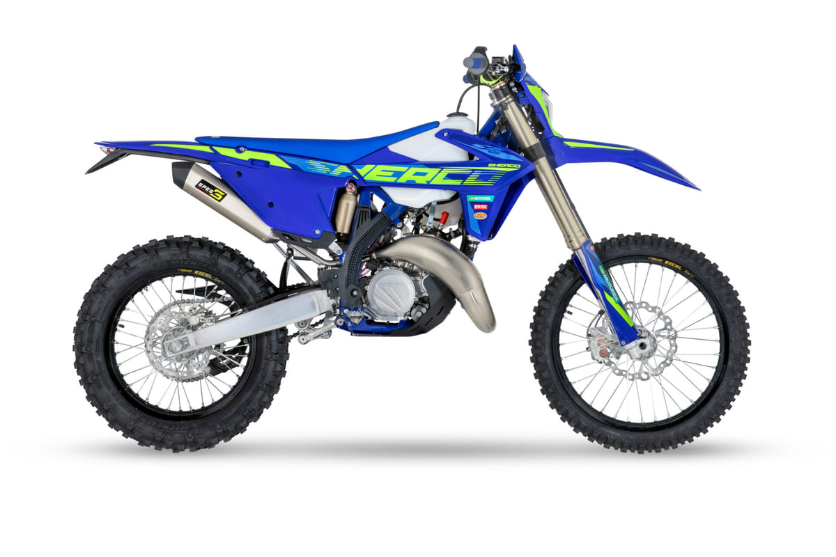 2027 Sherco 125 SE Factory enduro bike in blue with neon green graphics, right-side studio profile showing the exhaust and inverted forks