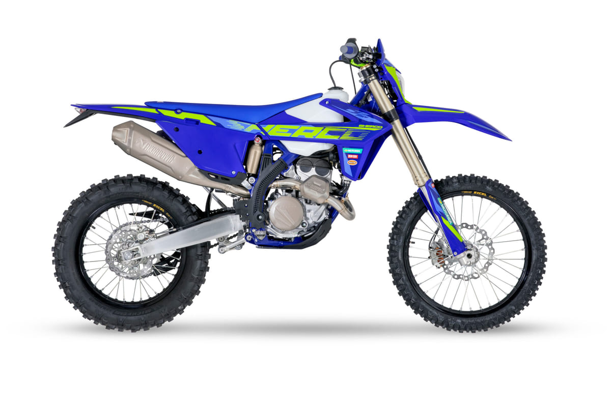 2027 Sherco 250 SEF Factory enduro bike in blue and white with neon green graphics, right-side studio profile showing the Akrapovic exhaust and gold fork tubes