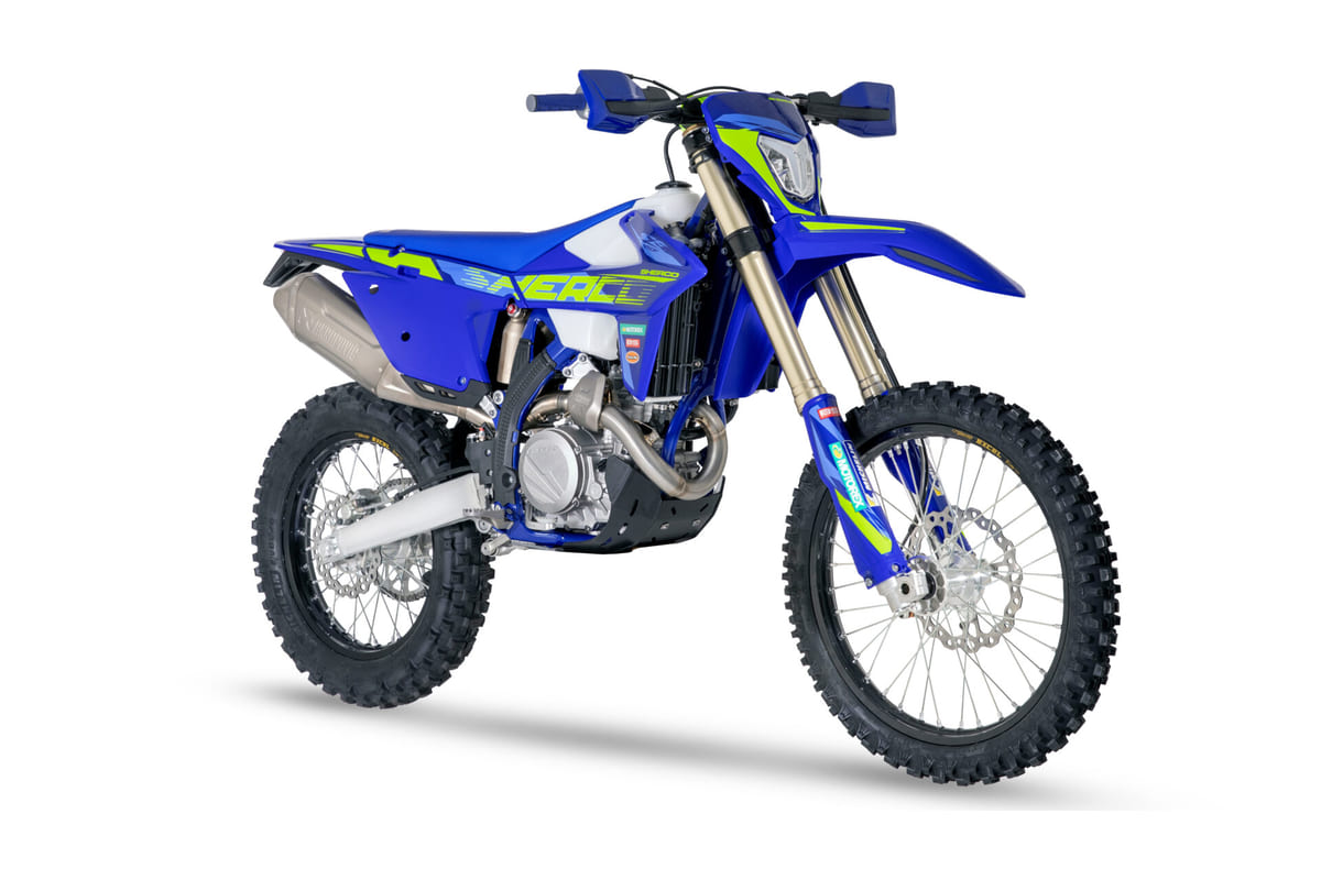 2027 Sherco 450 SEF Factory enduro bike in blue and yellow-green, front three-quarter studio profile showing the titanium exhaust and Kayaba forks