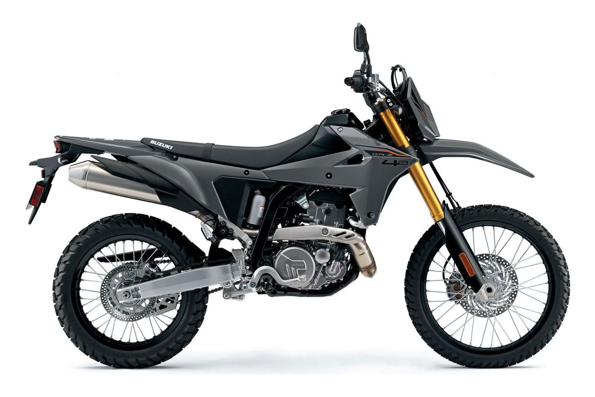 2026 Suzuki DR-Z4S dual-sport motorcycle in matte gray, right-side studio profile with gold-anodized forks and stubby stainless exhaust