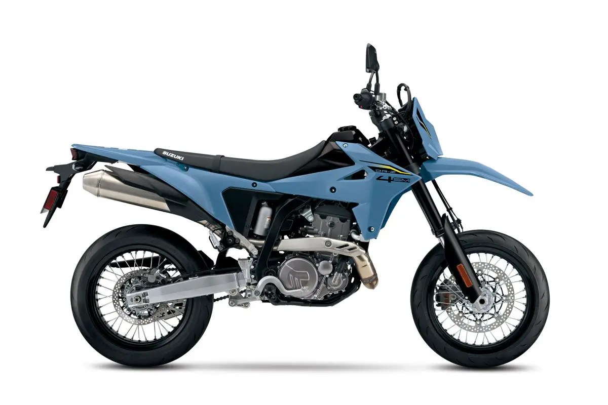 2026 Suzuki DR-Z4SM supermoto in matte blue, right-side studio profile showing the supermoto wheels, upswept exhaust and tall front fender