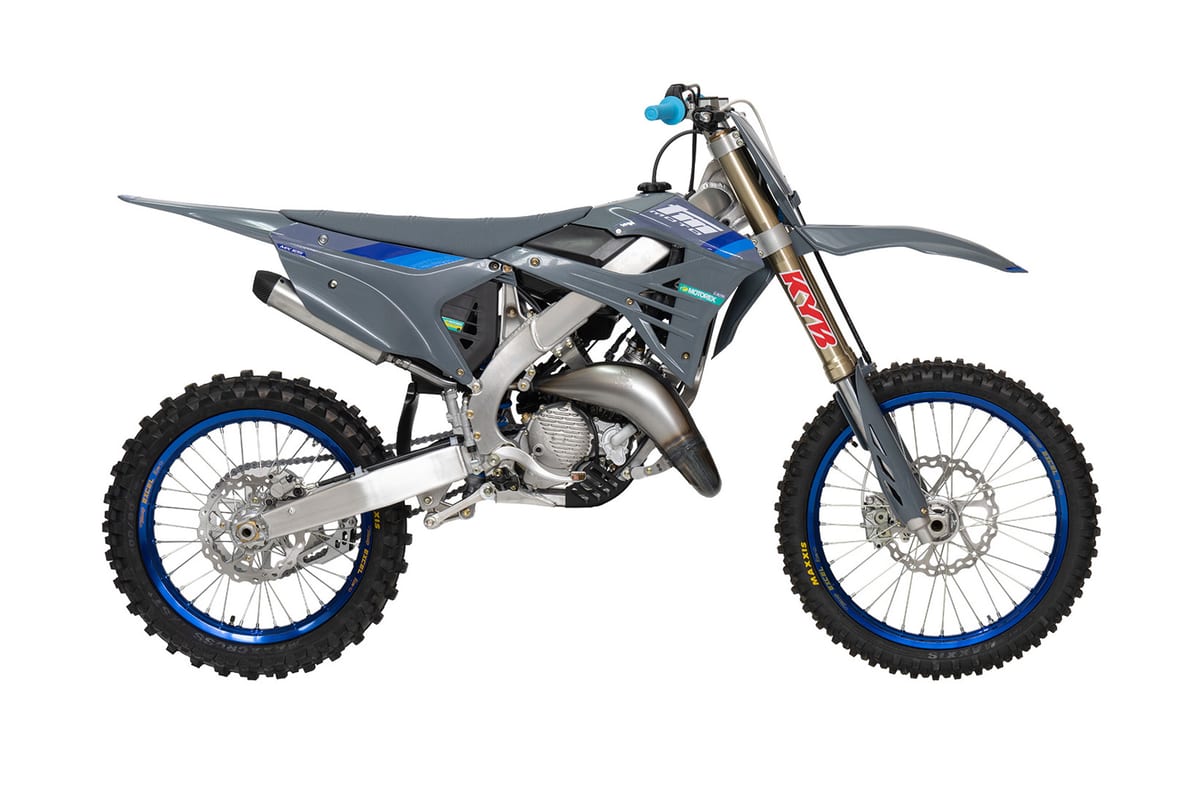 2026 TM MX 125 2T motocross bike in grey with blue graphics, right-side studio profile showing KYB forks, blue rims and twin-pipe exhaust
