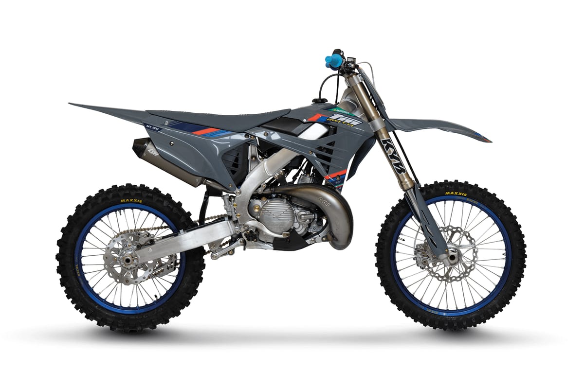 TM MX 300 FI 2T left-side studio profile against a white background, highlighting the two-stroke pipe, silver muffler and blue-rimmed spoked wheels