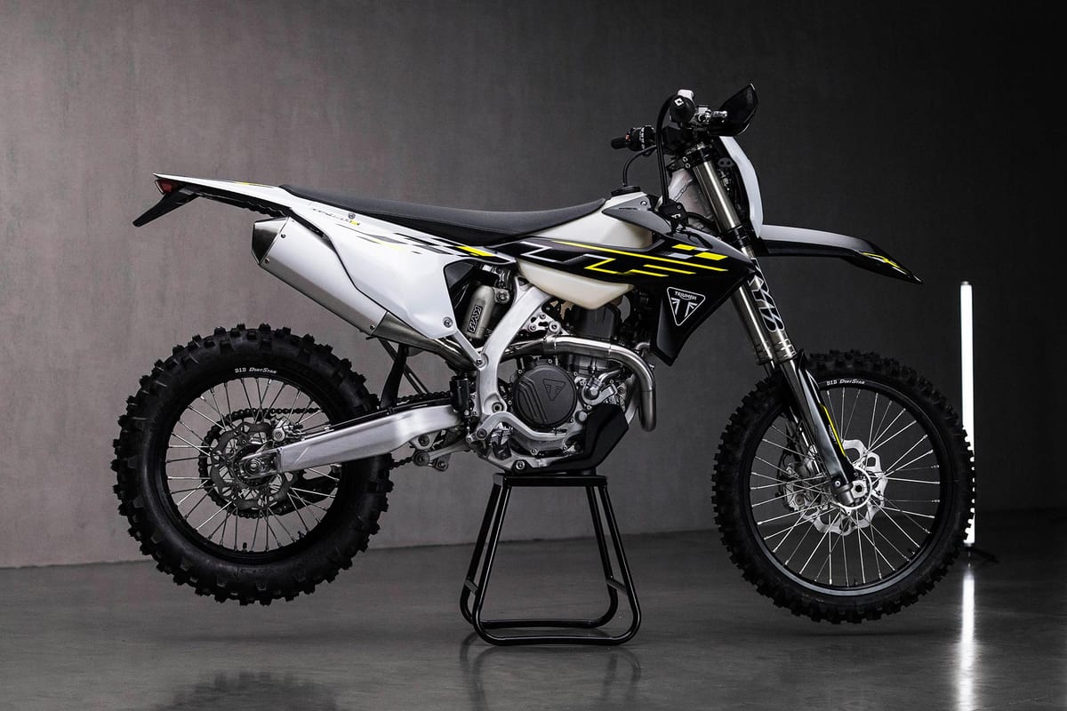2026 Triumph TF 450-E enduro in white and black with yellow accents, right-side studio profile showing the white exhaust can and inverted forks