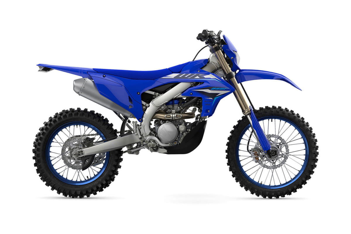 2026 Yamaha WR250F enduro in blue with white number plates, right-side studio profile showing the titanium exhaust, inverted forks and knobby tires