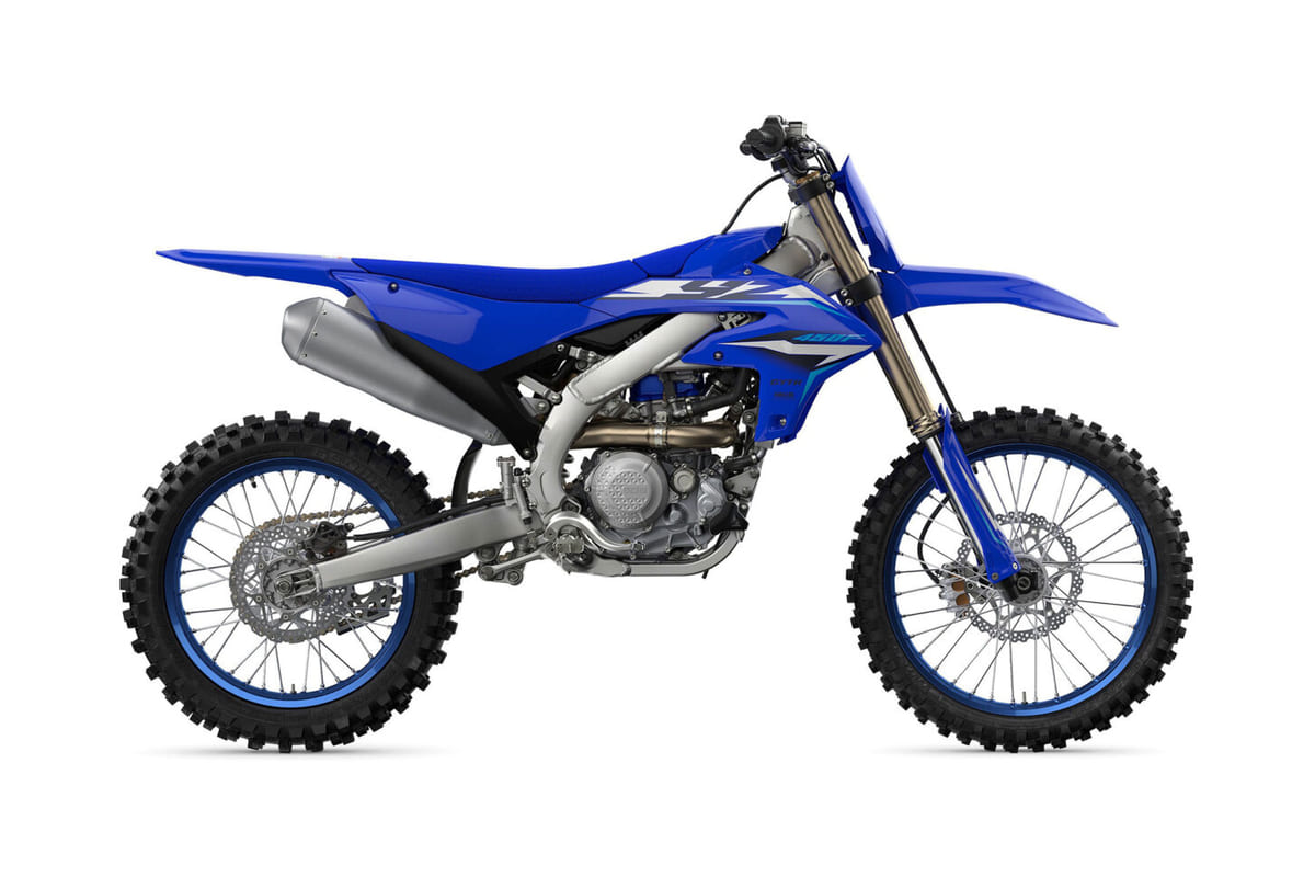 2027 Yamaha YZ450F motocross bike in blue and white, right-side studio profile showing the titanium exhaust and blue-rimmed spoke wheels
