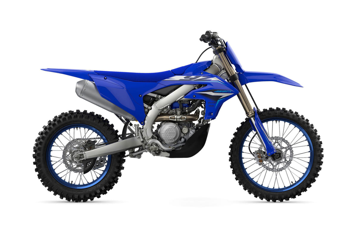 2027 Yamaha YZ450FX cross-country bike in blue and white, right-side studio profile showing the golden forks, twin-pipe silencer and spoked wheels